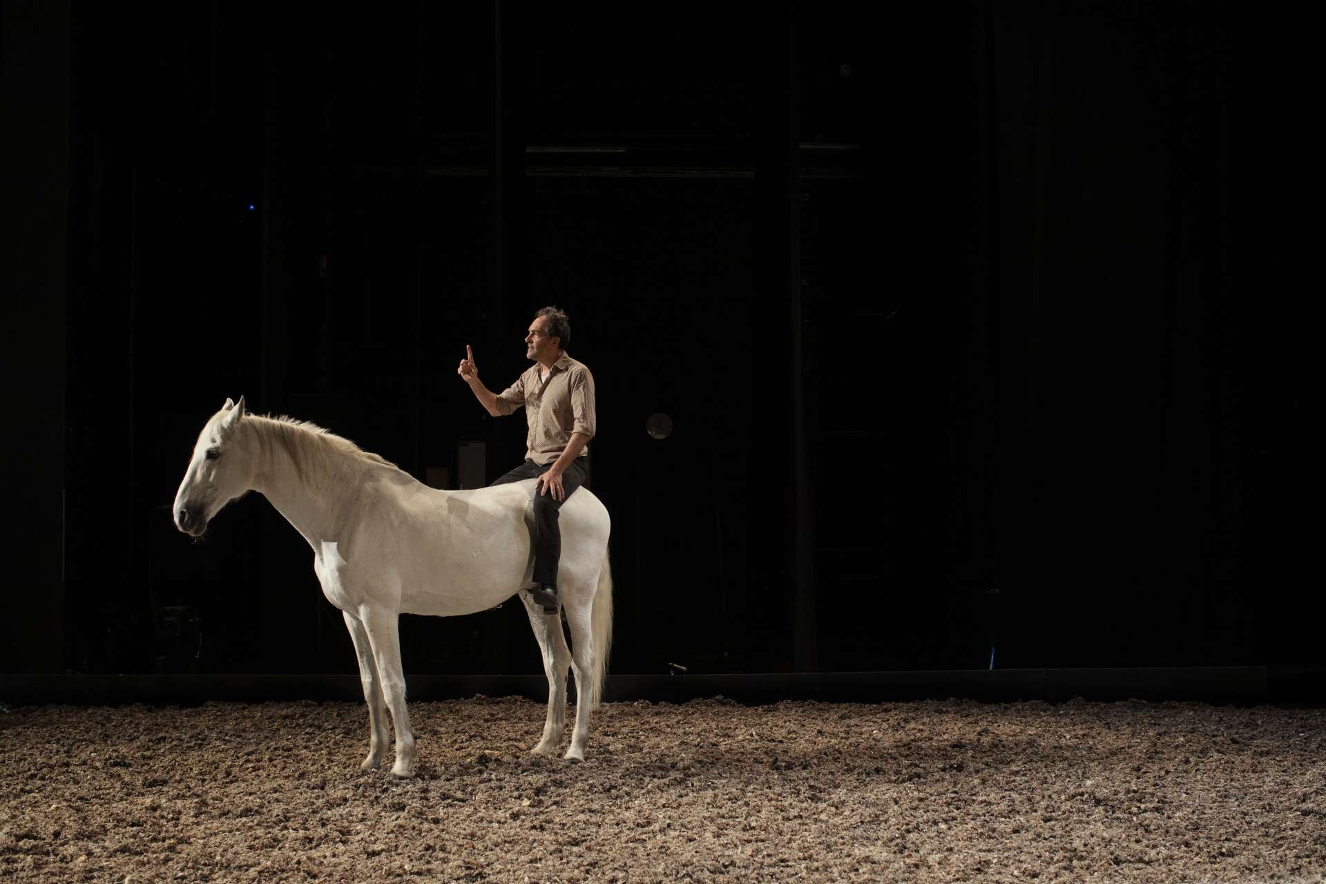 Le comédien Bertrand Bossard installé sur la croupe d'Akira, son cheval