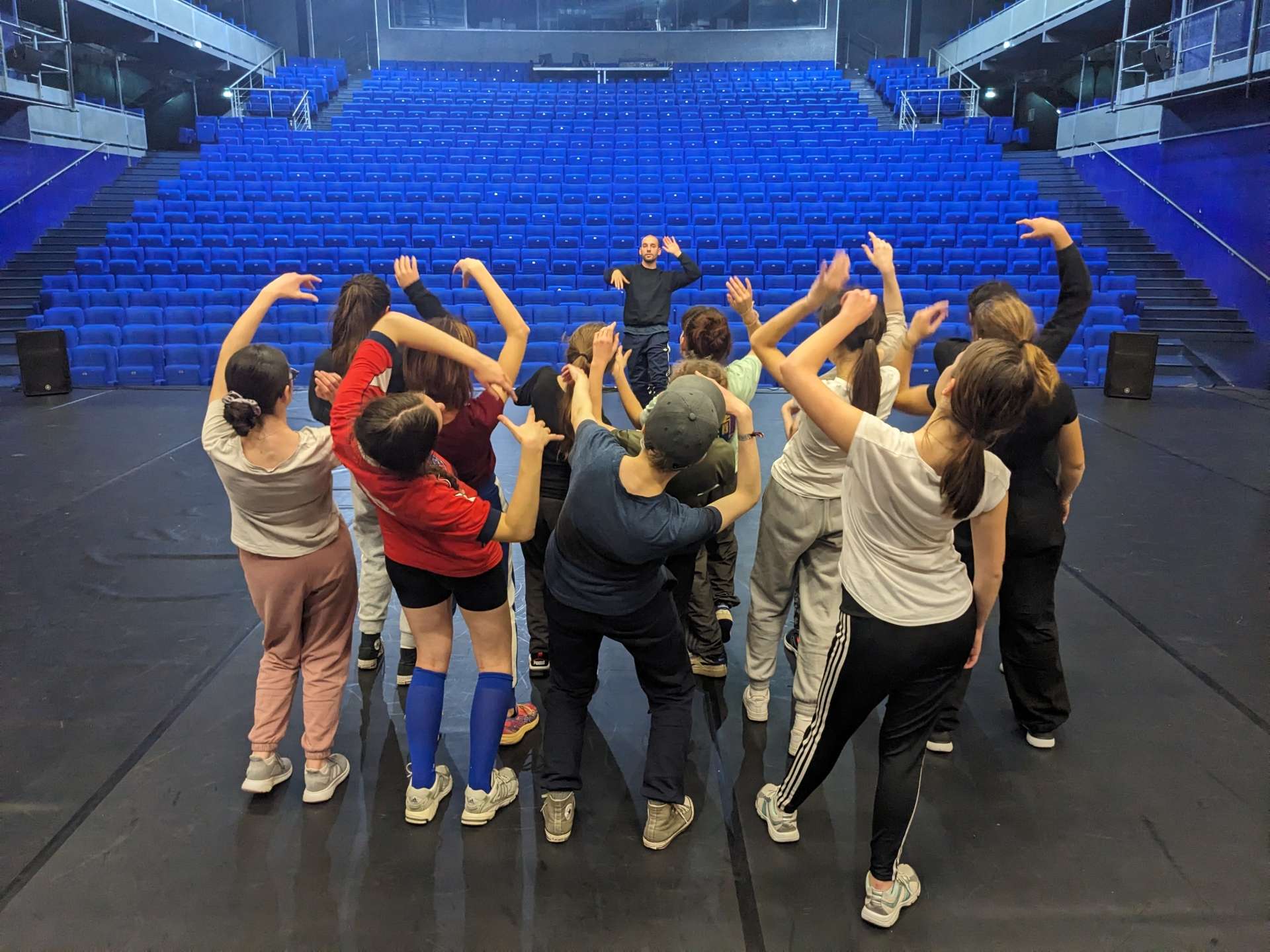 Salle Barrault, face aux fauteuils de couleur bleu et au chorégraphe Simon Dimouro, les jeunes amateurs du projet Sources effectuent une chorégraphie groupée.